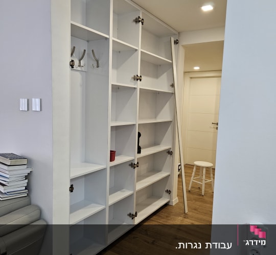 ארון מדפים לבן עם דלתות פתוחות וחלקי מתכת